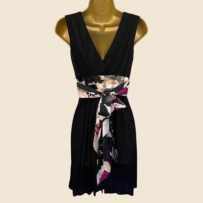 Black dress with a floral belt on a mannequin against a beige background