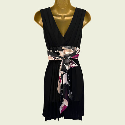 Black dress with a floral belt on a mannequin against a beige background
