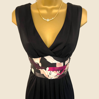 Black dress with floral patterned belt on a mannequin against a beige background