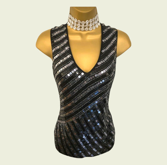 Black sequined top on a mannequin with a necklace on a beige background