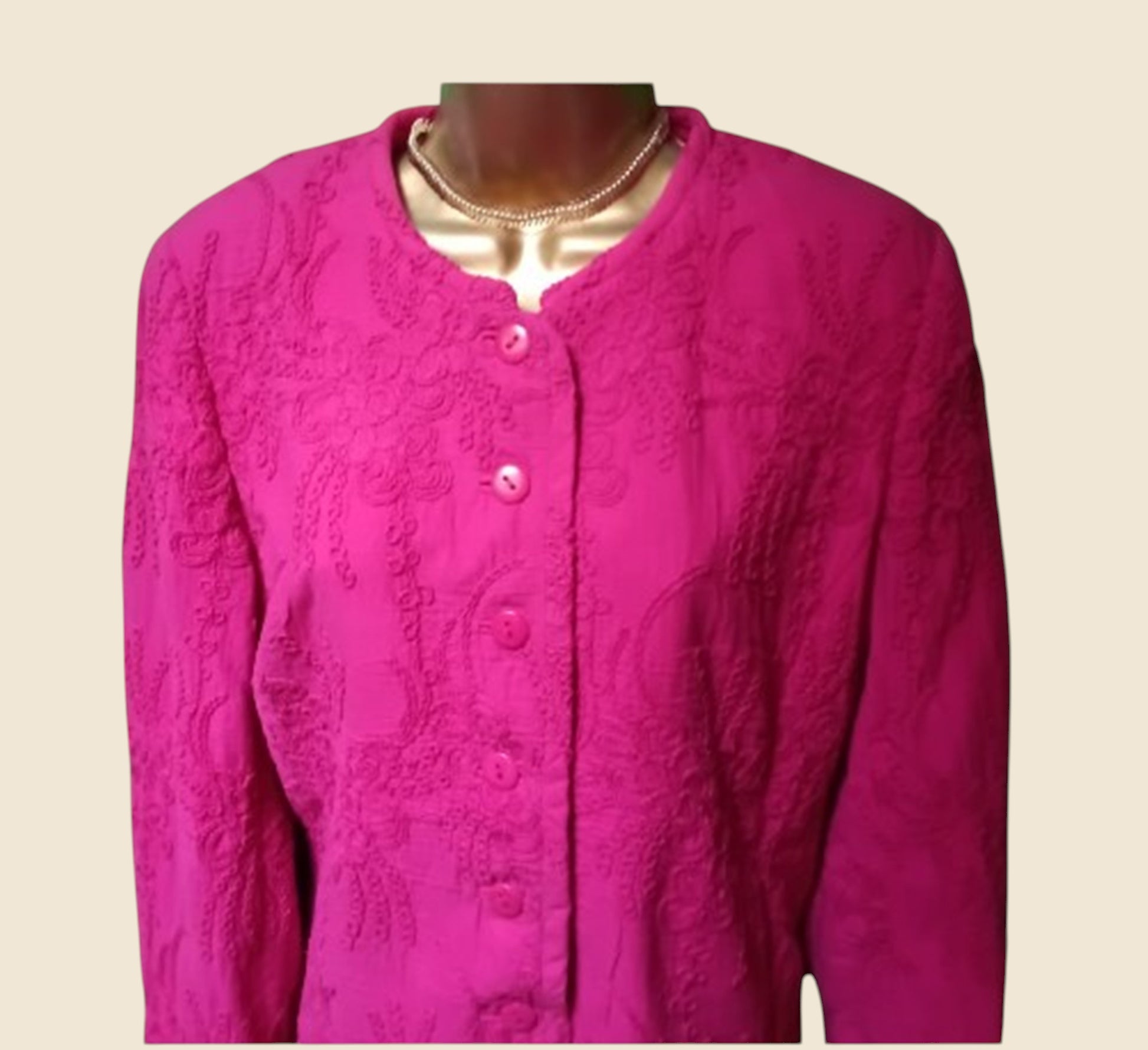 Pink textured jacket on a mannequin against a beige background