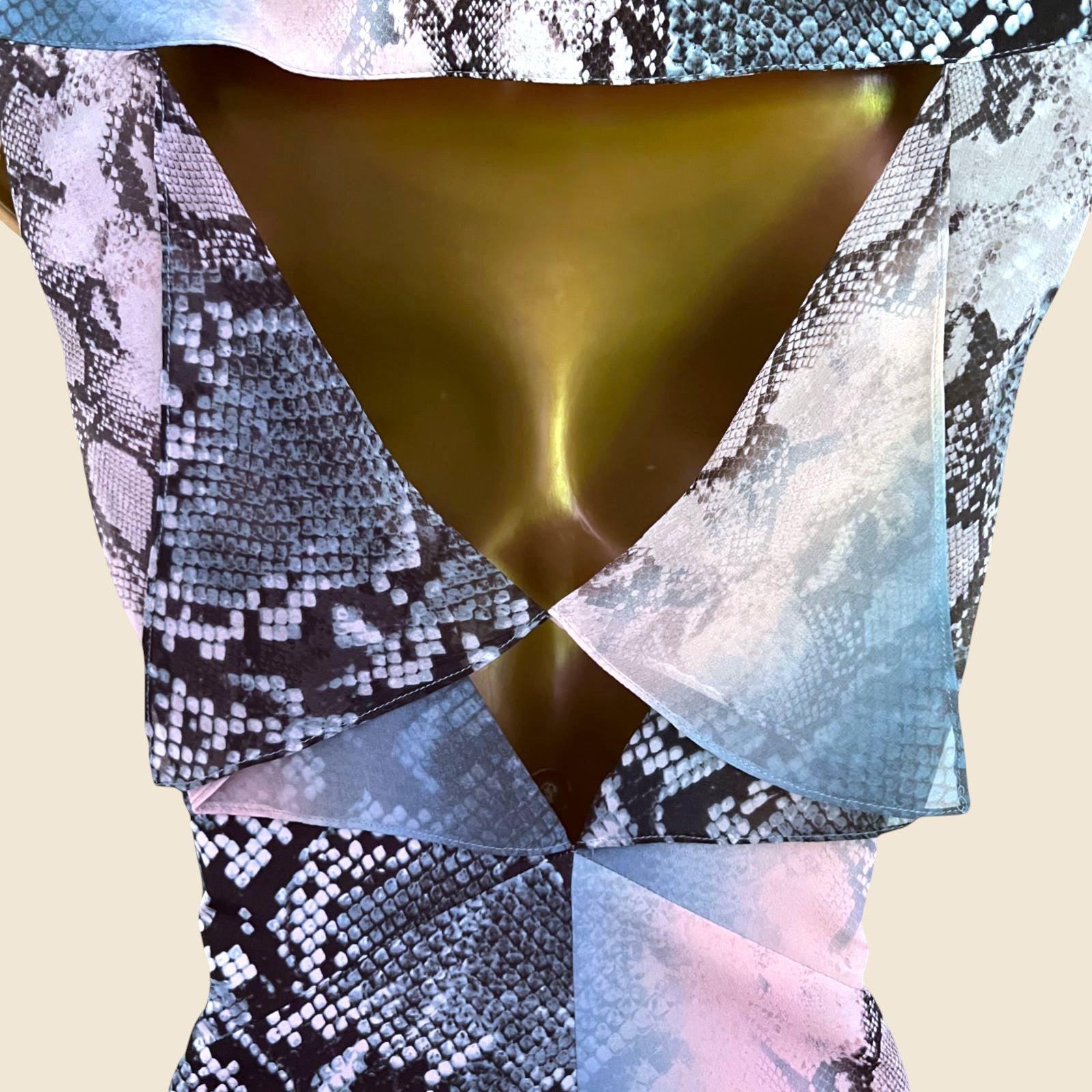Close-up of a patterned garment with a metallic gold center on a beige background