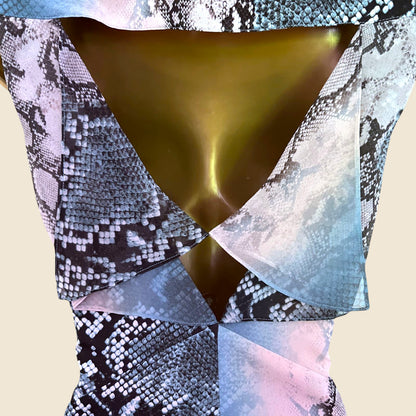 Close-up of a patterned garment with a metallic gold center on a beige background