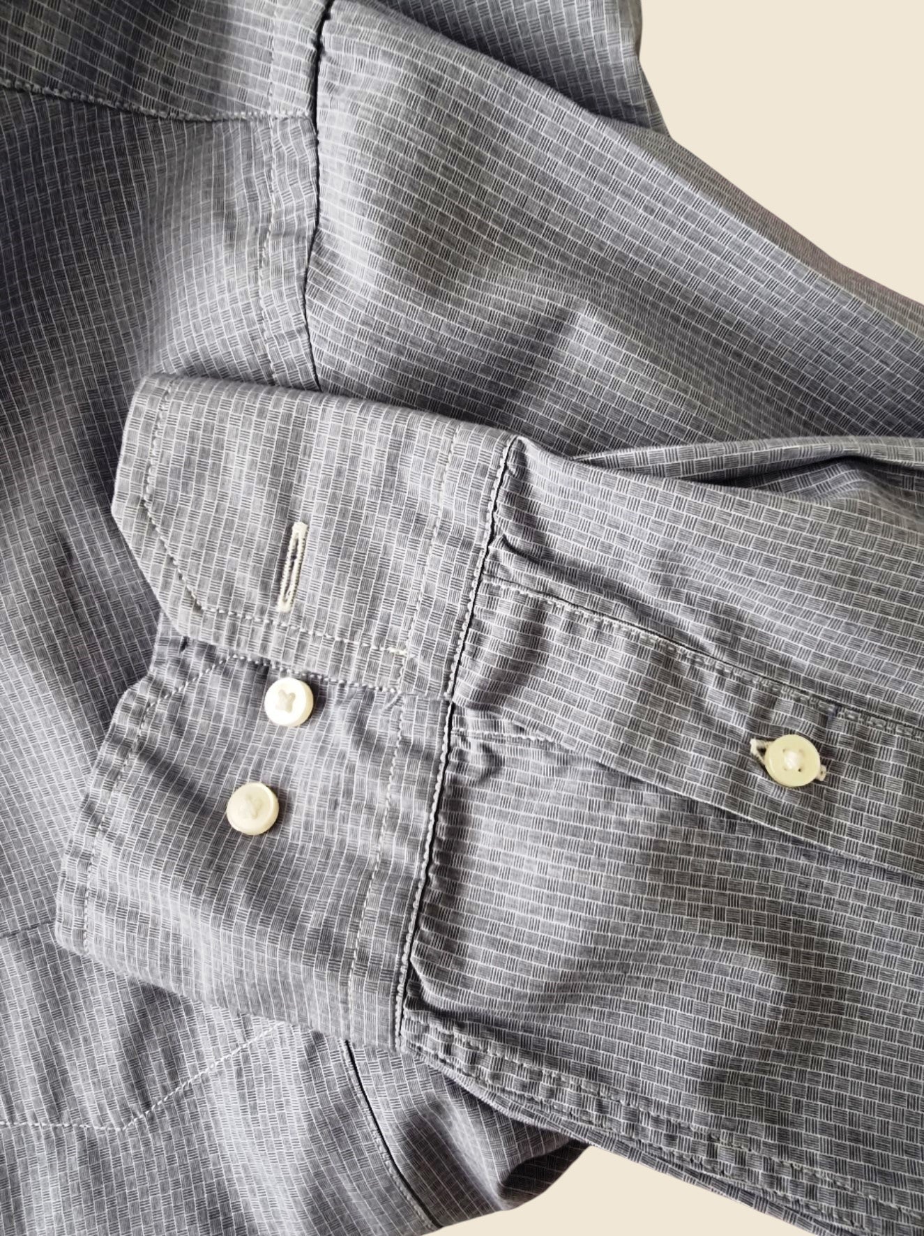 Close-up of a blue plaid shirt with buttons on a light background