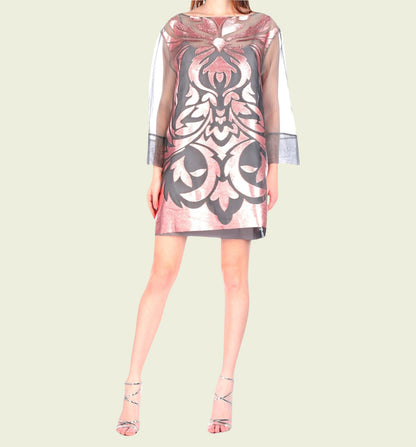 Woman wearing a patterned dress on a plain background