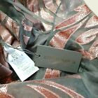 Metallic leaf-like object with a tag on a textured surface