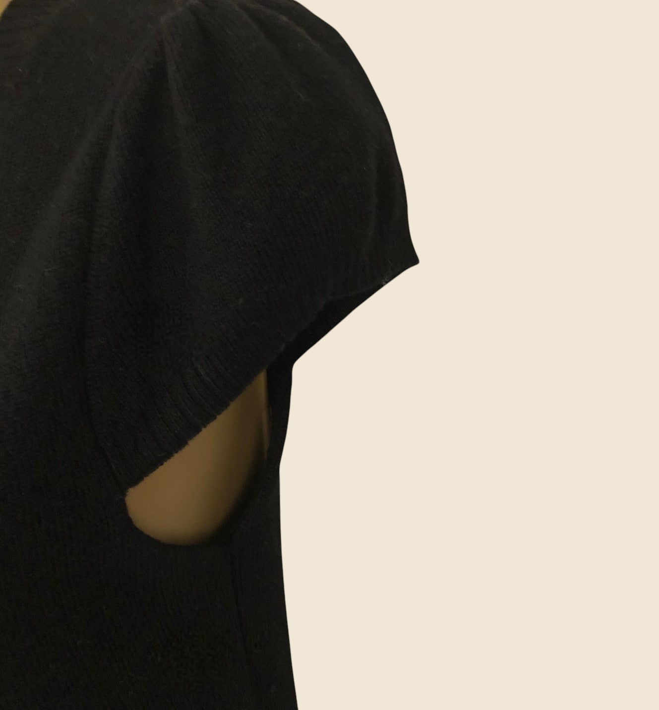 Black dress showing short sleeve on a beige background