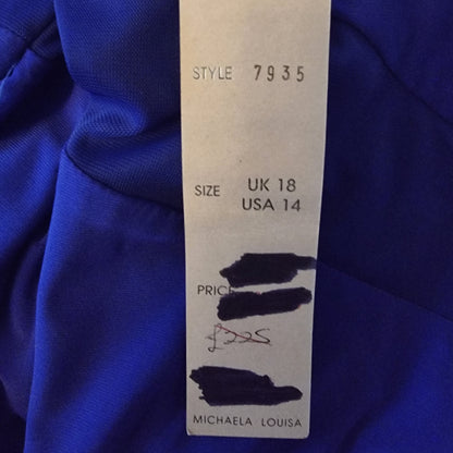 Clothing tag on a blue fabric background with size, style, and brand information.