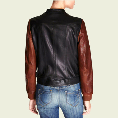 Person wearing a black and brown leather jacket with blue jeans on a beige background